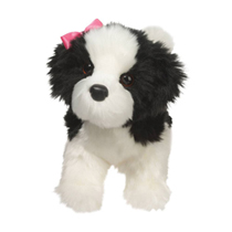 A black and white dog plush with a tiny pink bown on it's head.