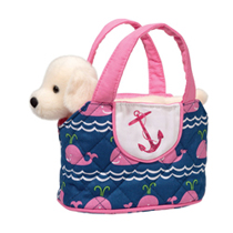 A plush white dog in a cute pink sac with whales on it.
