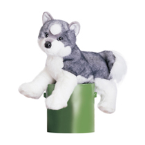 A gray and white husky plush sitting on a green bucket.
