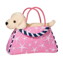 A puppy in a pink bag with little starfish printed on it.